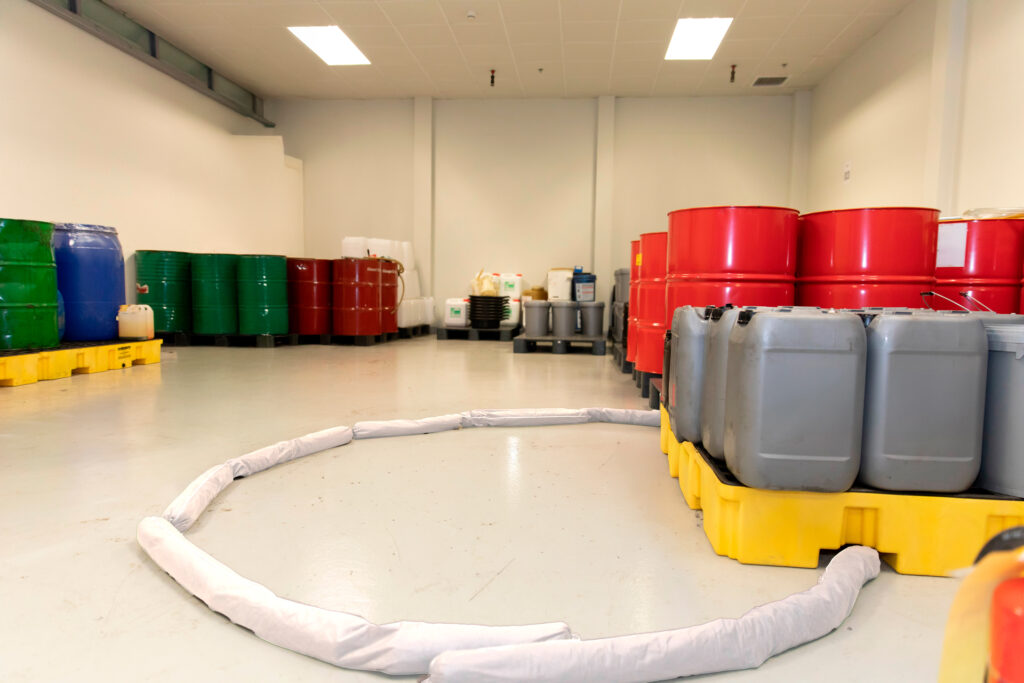 Lupa Ambiental | Pallets de contenção com tambores industriais, garantindo o armazenamento seguro e a prevenção de derramamentos de produtos químicos.